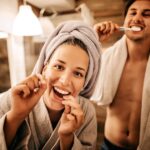 couple brushing and flossing, smile resolutions